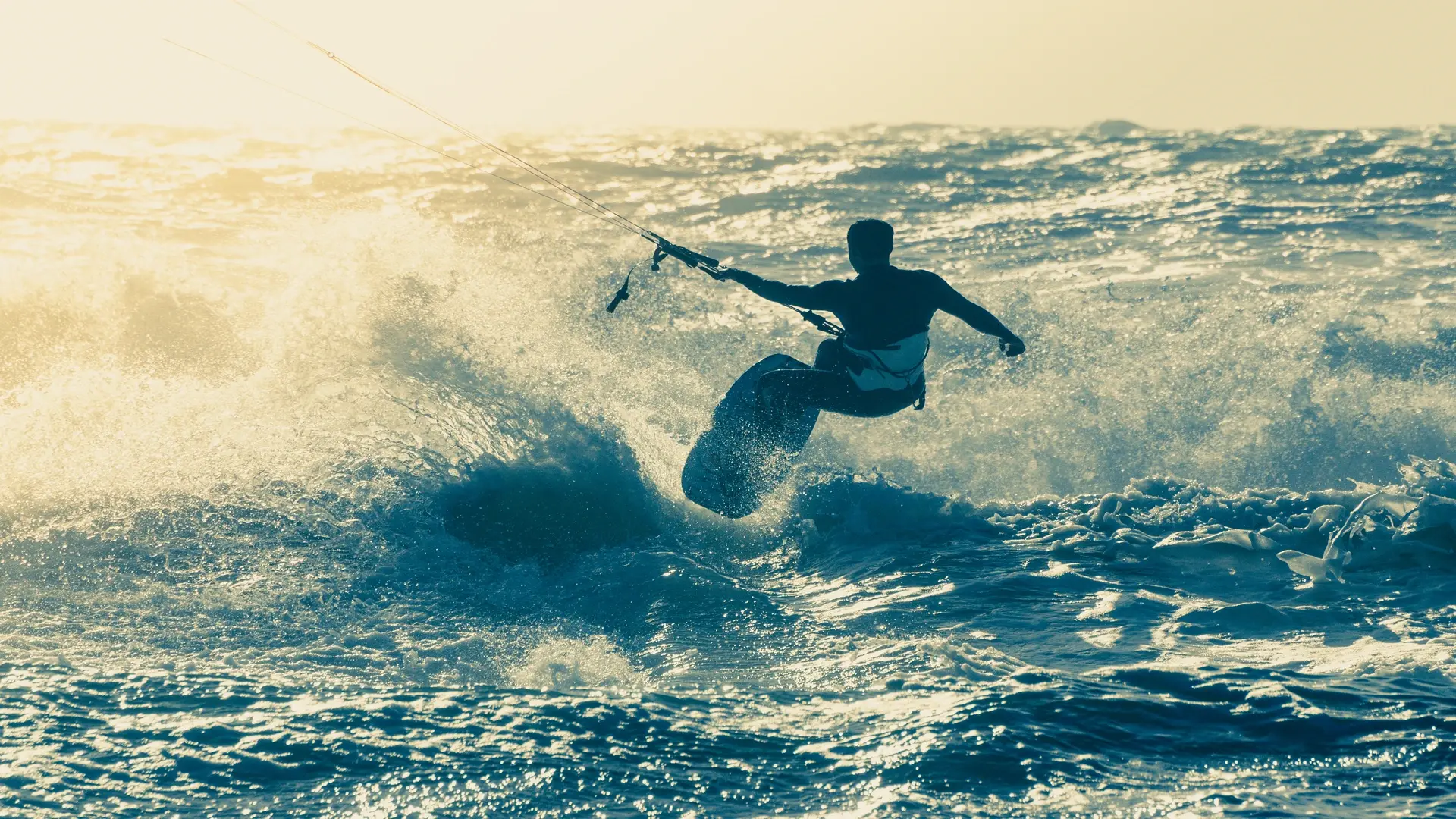 Kitesurfer riding the waves in the open ocean.